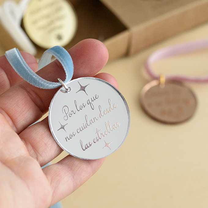 Primer plano de amuleto para el ramo de novia de AroruaBodas medalla circular espejo plata
