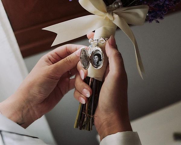 Novia con ramo de flores decorado con un camafeo con fotografía de Arorua Bodas