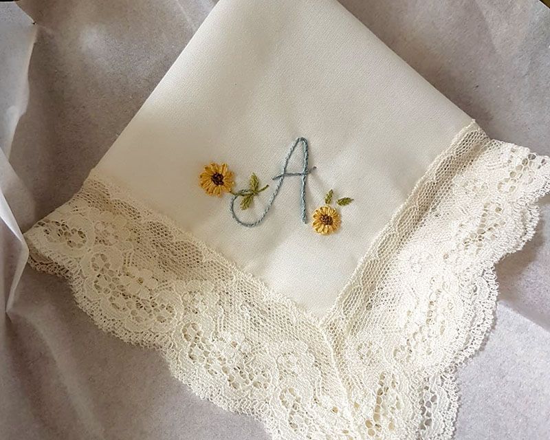 Pañuelo de ceremonia bordado a mano para novia con su inicial y unas flores de AroruaBodas